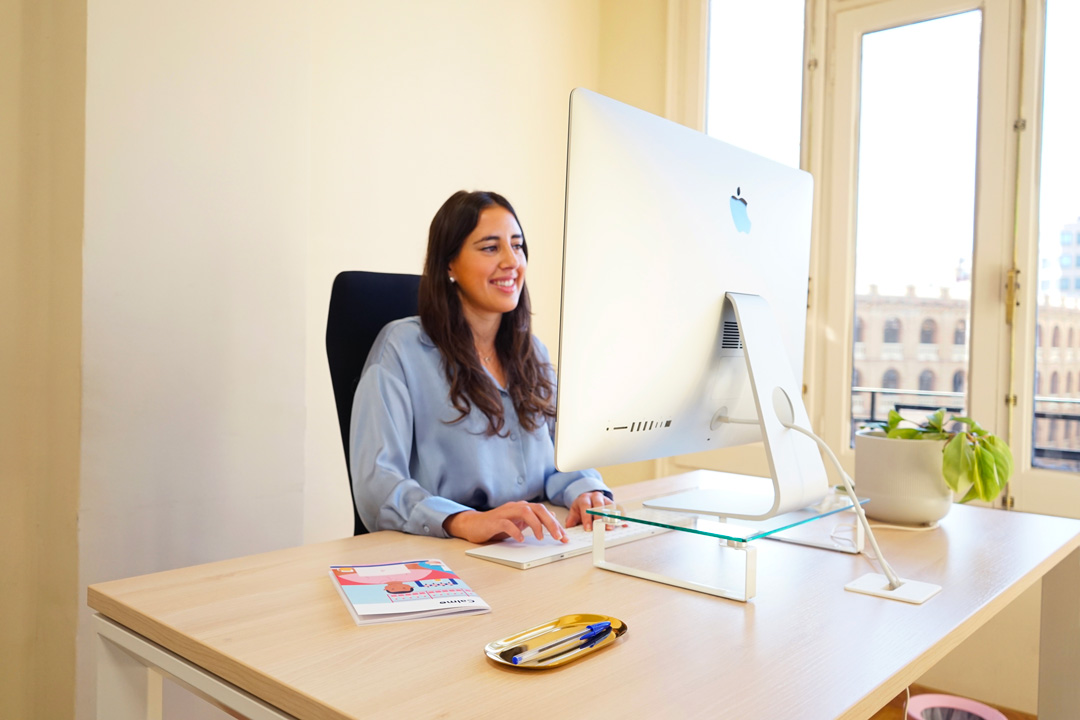 Diseñadora creativa en la oficina Calmo Agency en Valencia trabajando en un iMac